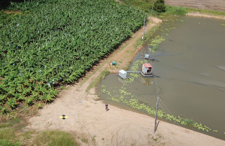 Banana crop monitoring showing the UAV operator (centre), landing target and obstacles–wires, water. Photo: Joe Urli