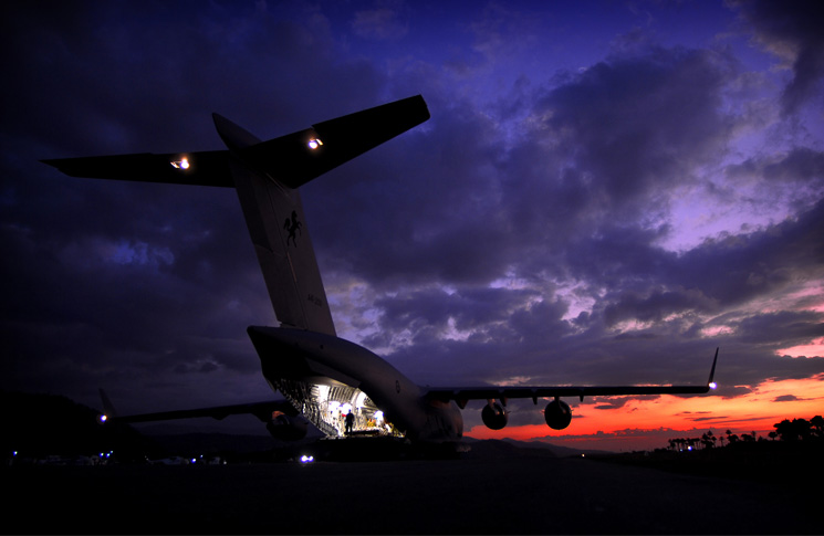 As the sun sets, a Royal Australian Air Force C-17 Globemaster sits on the tarmac after arriving at Dili International Airport, in East Timor
