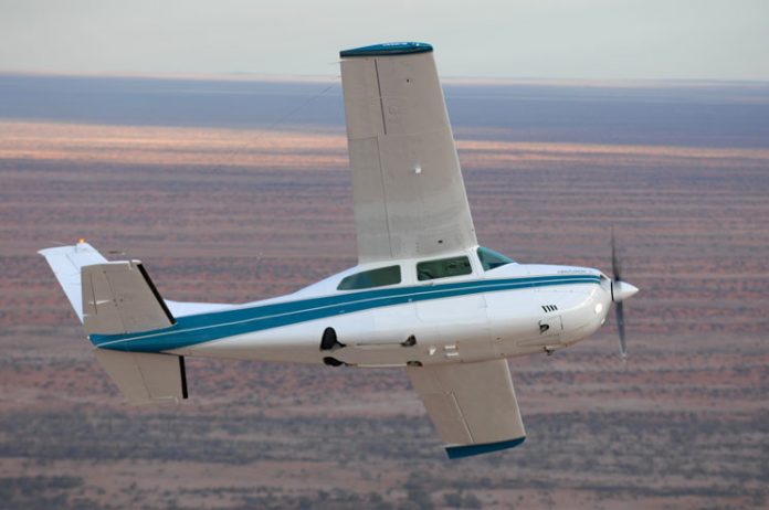 Image of a Cessna 210 aircraft flying