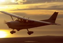 Cessna 172R flying at sunset.