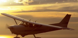 Cessna 172R flying at sunset.