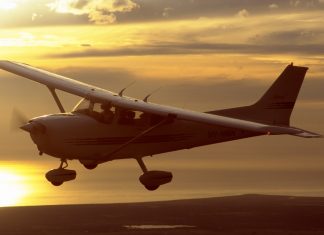 Cessna 172R flying at sunset.