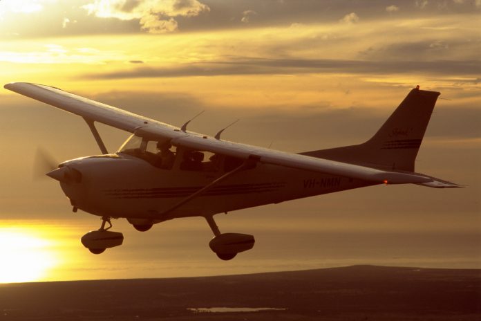 Cessna 172R flying at sunset.