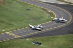 Aerial view of a Piper and Cessna lined up on the taxiway at Cairns Airport.