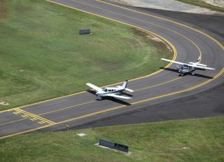 Aerial view of a Piper and Cessna lined up on the taxiway at Cairns Airport.