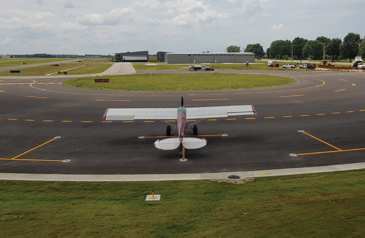 The tail dragger aircraft on the ground safely at the airport.