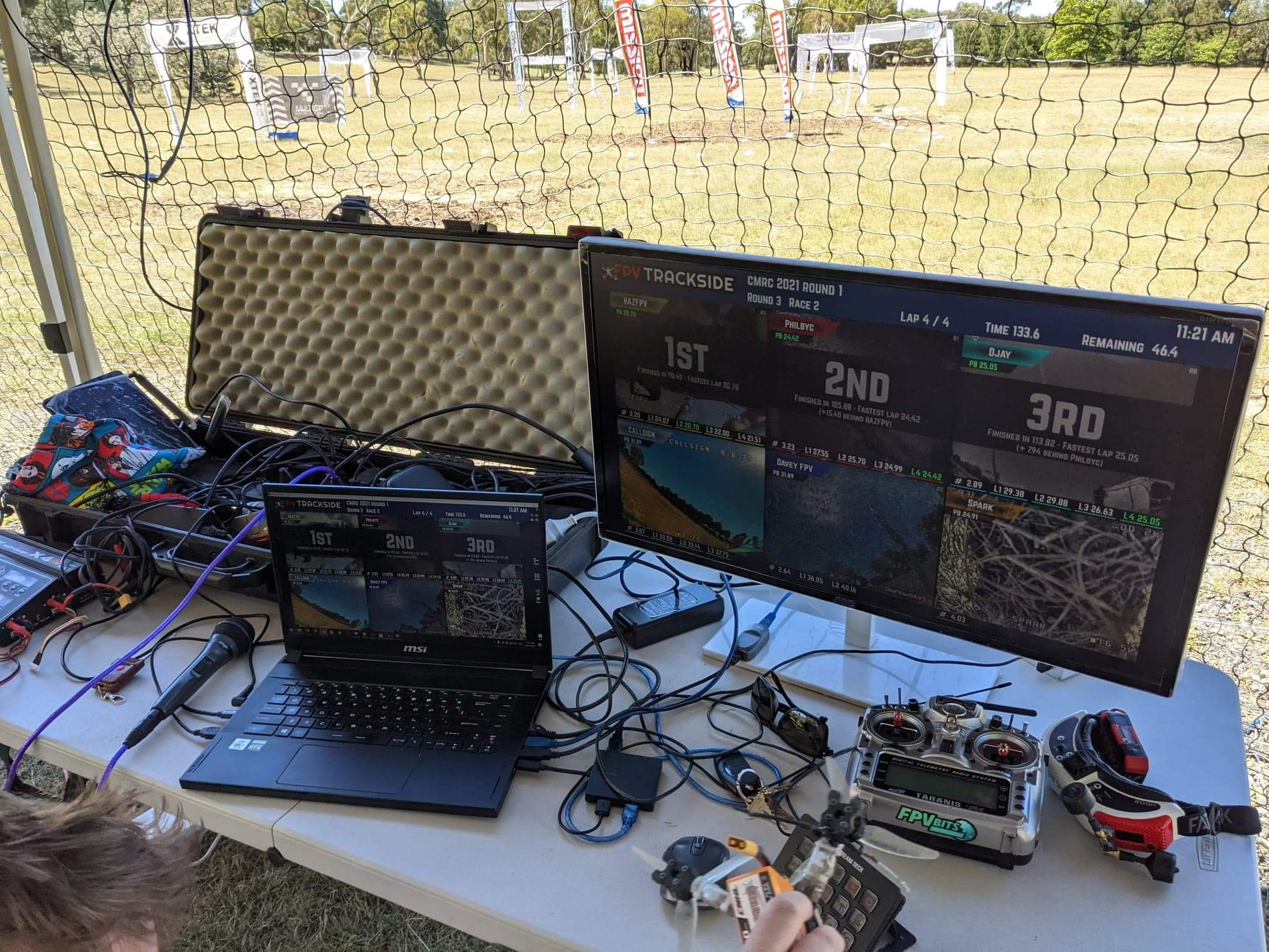 Race directions area. A laptop is used to run the lap timing system and keep track of heats. Safety netting is hung to protect pilots and spectators.
