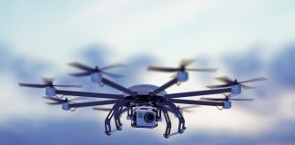 Octocopter drone flying against a dusk sky.