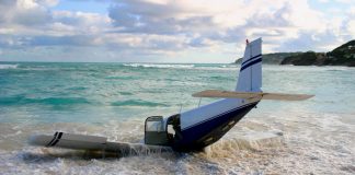 The wreckage of a light aircraft on a beach.