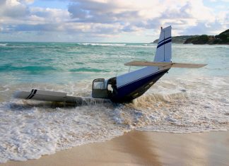 The wreckage of a light aircraft on a beach.