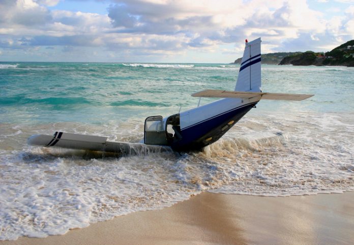 The wreckage of a light aircraft on a beach.