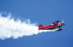 Airshow plane leaving a smoke trail on a blue sky background