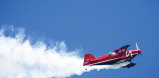 Airshow plane leaving a smoke trail on a blue sky background