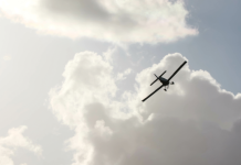 Small plane flying in a cloudy sky