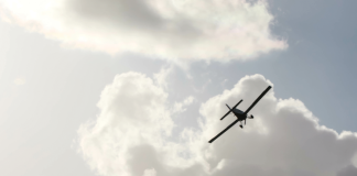 Small plane flying in a cloudy sky