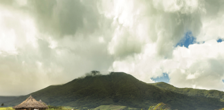 Lansdcape with grey clouds and a hut nestled within the grass