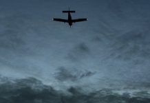 Silhouette of small aircraft in the sky at dusk