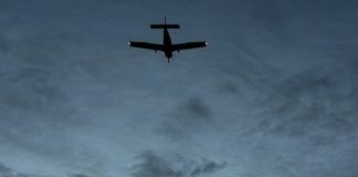 Silhouette of small aircraft in the sky at dusk