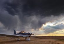 aircraft in a paddock with a cloudy stormy sky