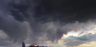 aircraft in a paddock with a cloudy stormy sky