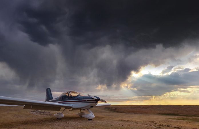 aircraft in a paddock with a cloudy stormy sky