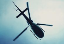Silhouette view from below of a helicopter in the sky