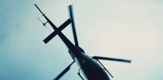 Silhouette view from below of a helicopter in the sky