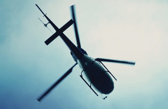 Silhouette view from below of a helicopter in the sky