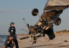 Two police officer investigating a gyrocopter crash on a beach.
