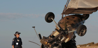 Two police officer investigating a gyrocopter crash on a beach.