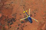 Photo by Ashley Kelly. AS.350BA Eurocopter flying over a red outback.