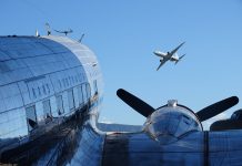 Photo by Ian Leithhead. Parked Trans Australia Airlines Douglas DC-3 and Boeing P-8 Poseidon in flight overhead.