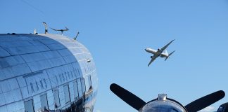 Photo by Ian Leithhead. Parked Trans Australia Airlines Douglas DC-3 and Boeing P-8 Poseidon in flight overhead.