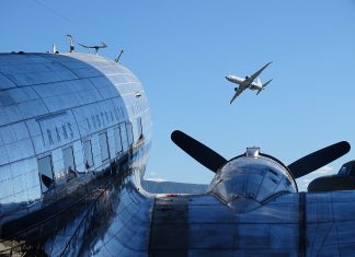 Photo by Ian Leithhead. Parked Trans Australia Airlines Douglas DC-3 and Boeing P-8 Poseidon in flight overhead.