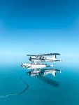 Photo by Izzy J Ryan. Dehavilland Beaver seaplane floating on calm waters, Hardy Lagoon, Great Barrier Reef.