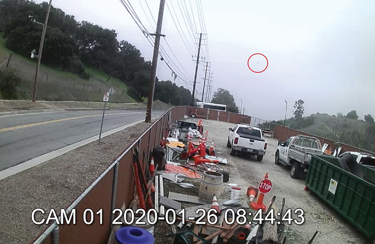 From a camera on US 101 at 0944:20 of the accident helicopter (circled in red). | NTSB