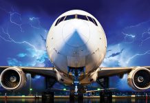 Stationary aircraft on tarmac during a lightning storm.