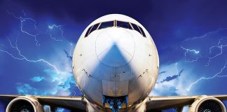 Stationary aircraft on tarmac during a lightning storm.