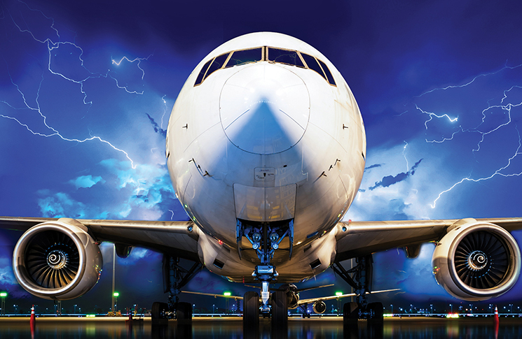 Stationary aircraft on tarmac during a lightning storm.