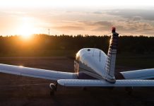 Aircraft parked at an airfield. Rear view of a plane with a propeller on a sunset background.