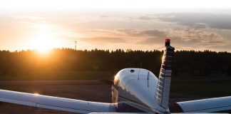 Aircraft parked at an airfield. Rear view of a plane with a propeller on a sunset background.