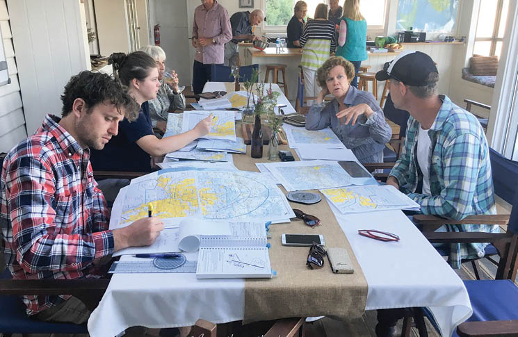 People at a table involved in flight planning.