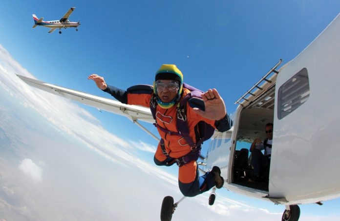 Skydiver jumping out of a plane with a second small aircraft in the background
