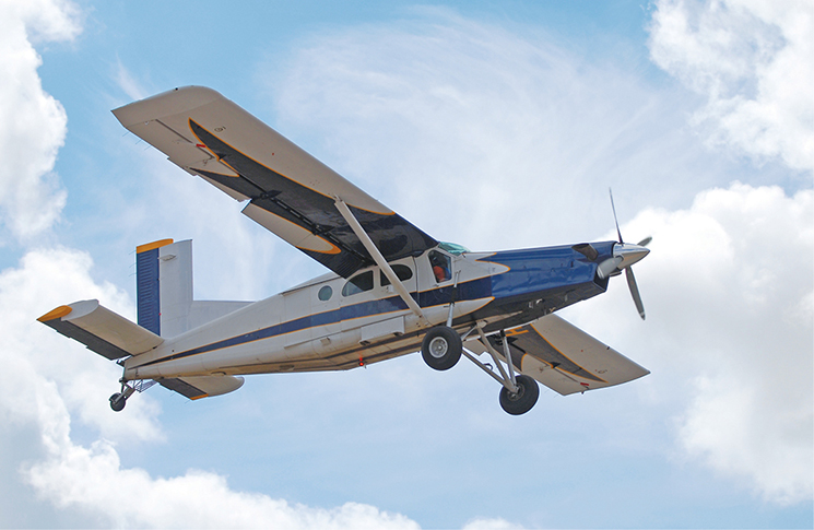 Photo of Pilatus PC-6 Turbo Porter flying in a blue sky with some cloud