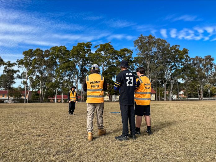 A student operating a drone in a field