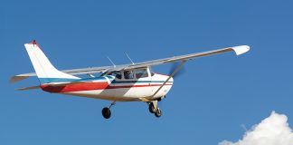 Small plane flying among the clouds and blue sky