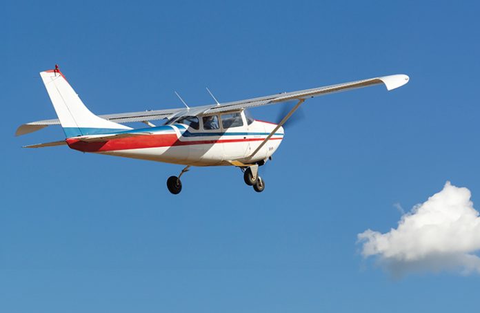 Small plane flying among the clouds and blue sky