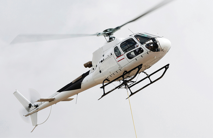 White helicopter flying in a cloudy white sky