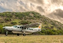 aircraft on a grass strip in front of a hill