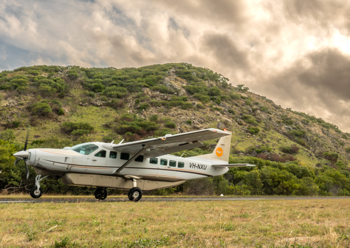 aircraft on a grass strip in front of a hill